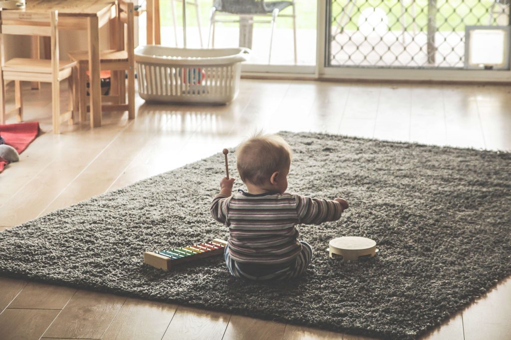 Bebé jugando en el piso en su hogar seguro