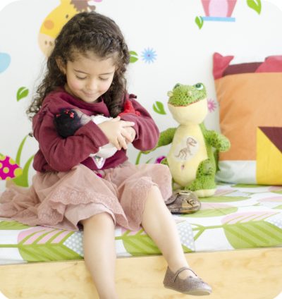 Niña de 5 años jugando con su muñeca en consulta con pediatra en Medellín